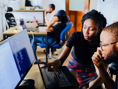 Two people working on a computer in an office.