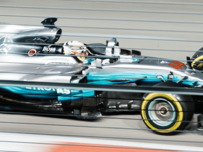 A mercedes racing car is speeding down the track.