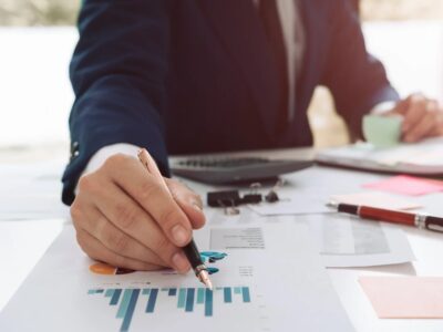 A businessman in a suit is writing on a piece of paper.