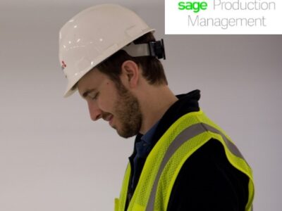 A man in a hard hat looking at his phone.