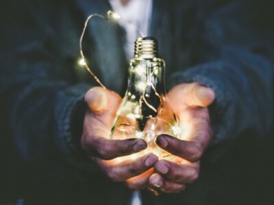 A person holding a light bulb in their hands.