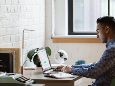 A man sitting at a desk using a laptop.