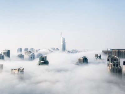 A city covered in clouds above a skyscraper.
