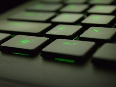 A close up of a black keyboard with green keys.