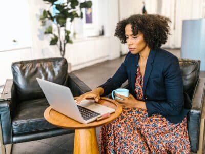 A woman working on a laptop in an office.