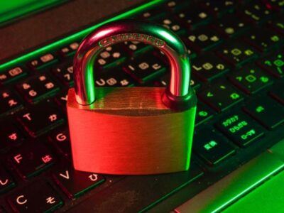 A padlock sits on top of a laptop keyboard.