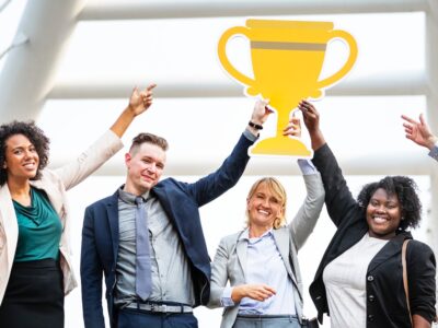 A group of business people holding up a trophy.