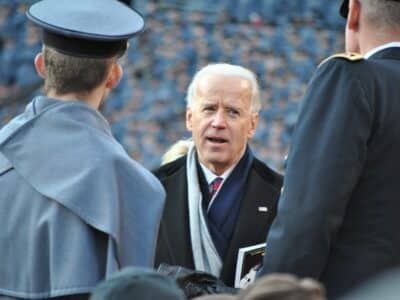 Joe Biden speaks to a group of men at a ceremony.