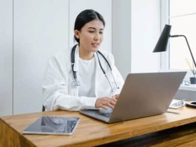 A female doctor working on her laptop at home.