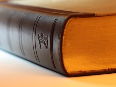 A close up of a brown book on a white surface.
