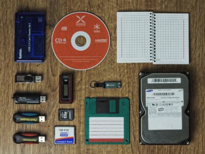 A group of items including a hard drive, cd, and a notebook.