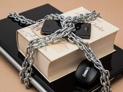 A book with a chain on it and a mouse on top of it.