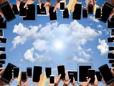 A group of people holding cell phones in a circle.