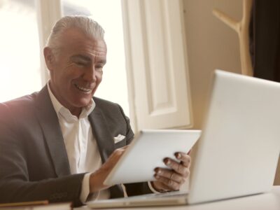 A man in a suit is using a tablet computer.