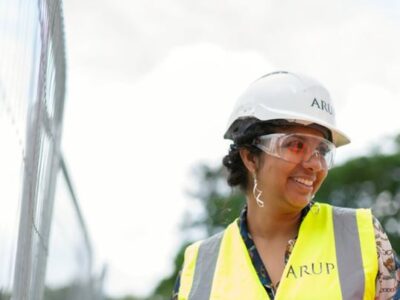 A woman wearing a hard hat and safety vest.