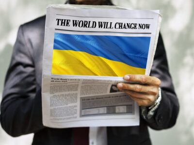 A man holding a newspaper with the Ukrainian flag on it.