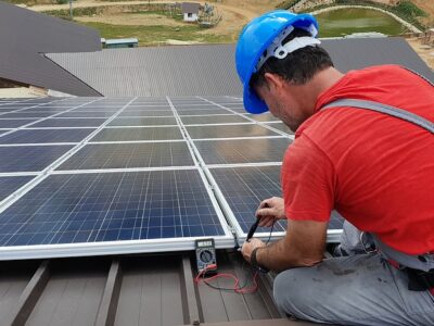 A man working on a solar panel on a roof.