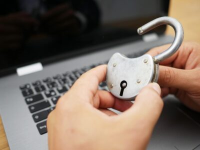 A person holding a padlock on a laptop.