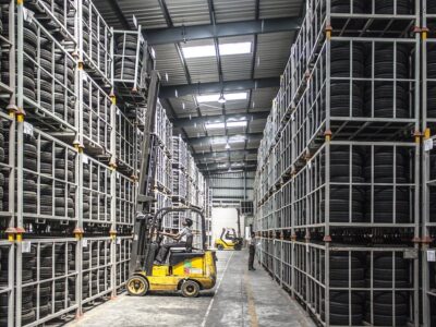 A forklift drives through a warehouse full of tires.