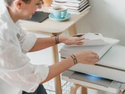 A woman is using a printer in her home office.