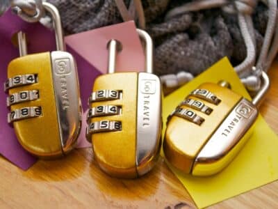 Three yellow padlocks on a wooden table.