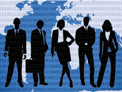 Silhouettes of business people standing in front of a world map.