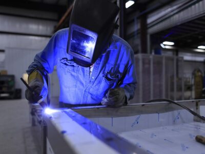 A welder working on a piece of metal in a factory.