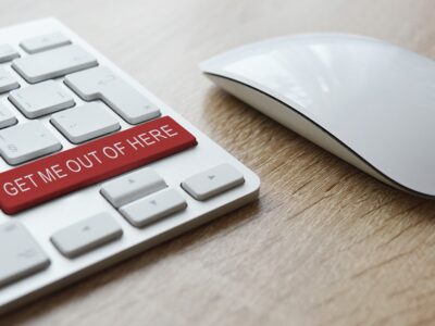 A computer keyboard with a red button that says get me out of here.