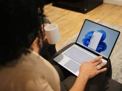 Two people sitting on a couch with a laptop and a cup of coffee.