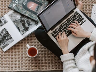 A woman working on a laptop with a cup of coffee.