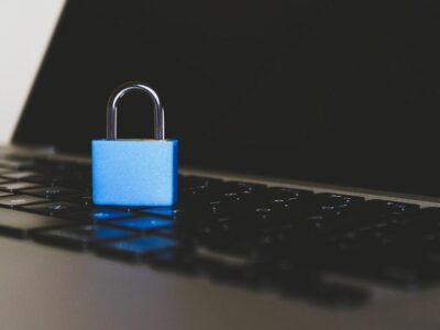 A blue padlock sits on top of a laptop keyboard.
