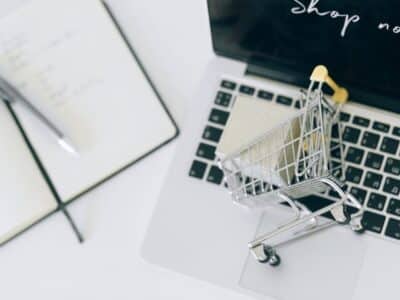 A toy shopping cart resting on top of laptop keyboard.