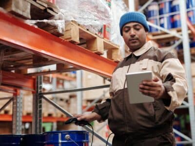 A warehouse worker using a tablet in a warehouse.