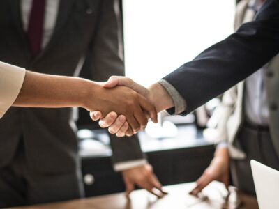 A group of business people shaking hands over a table.