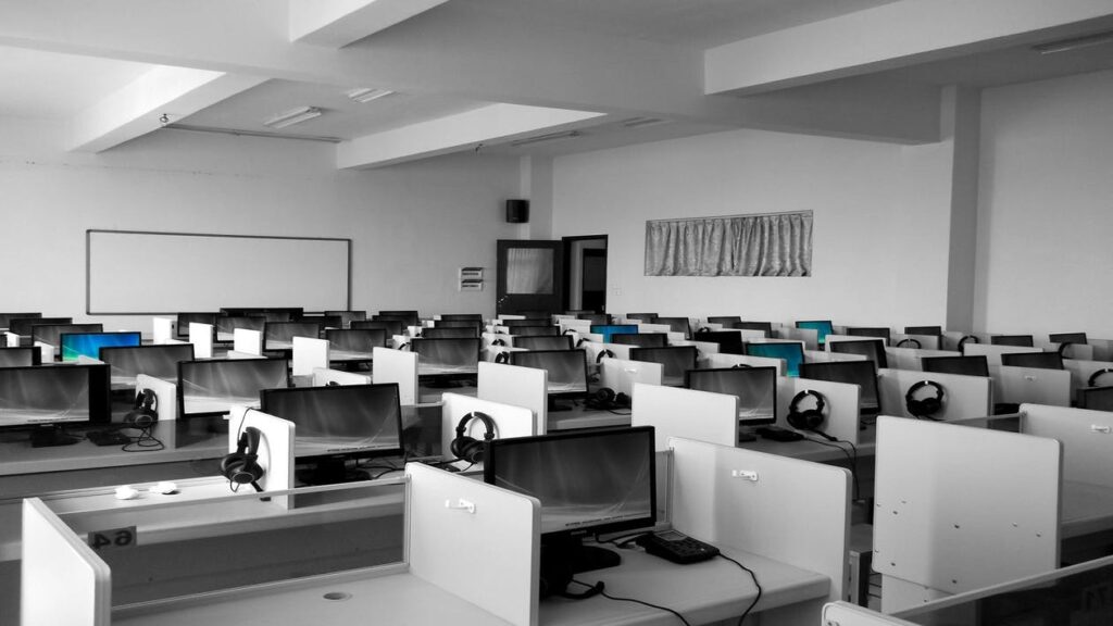 A black and white photo of a classroom full of computers.