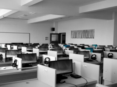 A black and white photo of a classroom full of computers.