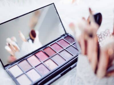 A makeup palette and brushes on a white background.