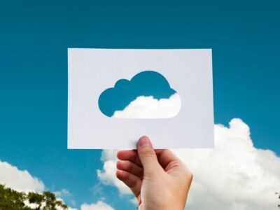 A person holding up a paper with a cloud on it.