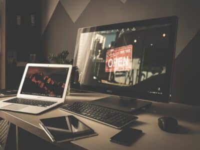 A desk with a laptop, monitor, and keyboard.