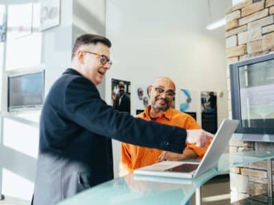 Two men looking at a laptop in an office.