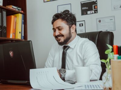 A man sitting at his desk with a laptop in front of him.