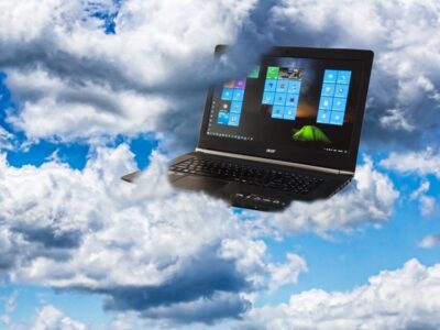 A laptop is flying through the clouds.