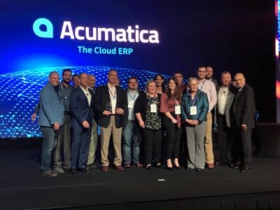 A group of people posing for a picture with the words Acumatica the Cloud ERP.