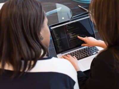 Two women working on a laptop.