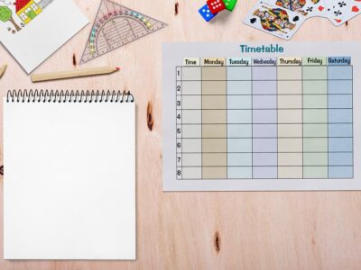 A calendar with a notepad and a notebook on a wooden table.