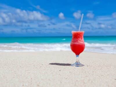 A cocktail on the beach with a straw.