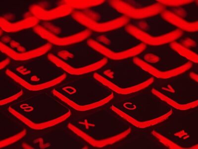 A close up image of a computer keyboard with red lights.