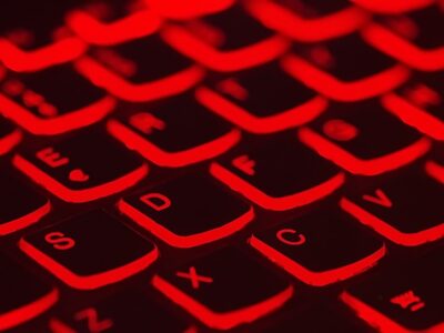 A close up image of a computer keyboard with red lights.