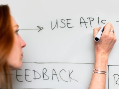 A woman writing on a whiteboard with the words use apis.