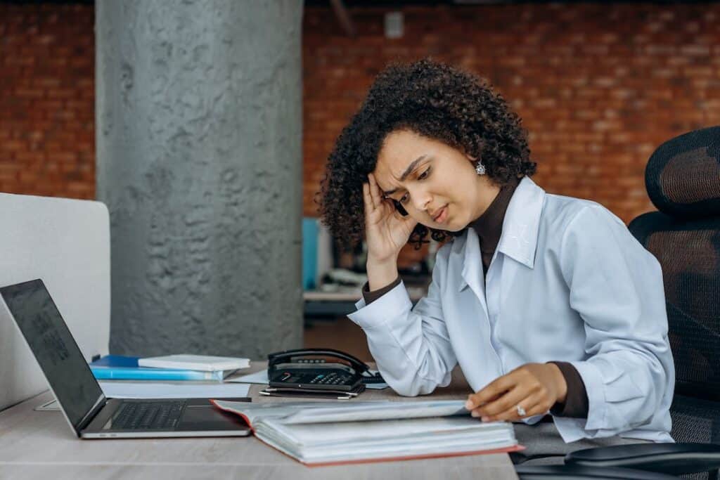 woman hunched over ledger at her desk after news of quickbooks desktop subscription cut off